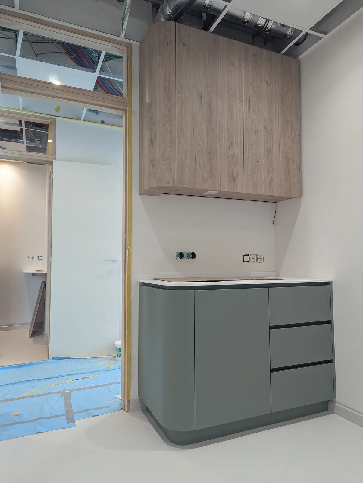 Groen praktijkmeubel op maat met eiken kastenwand