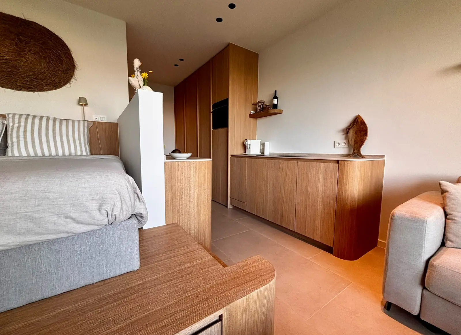 Studio met eiken keukenwand en zwevend dressoir met afgeronde zijkanten